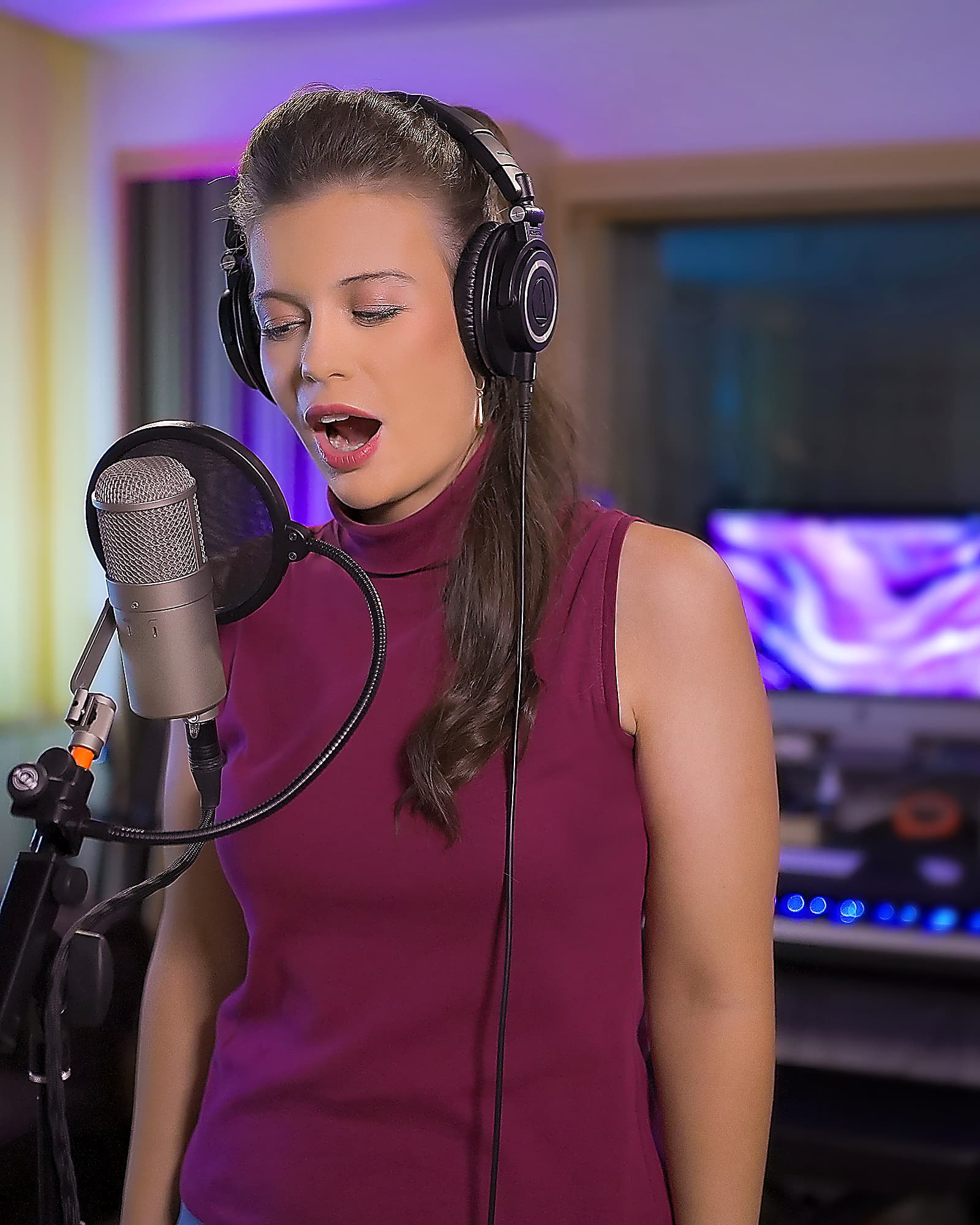 GLORIALLE singing at the studio microphone